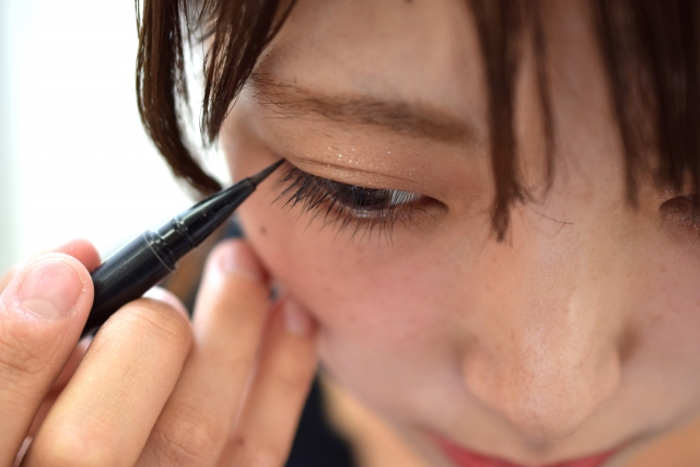 アイラインを引く女性
